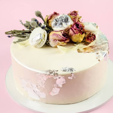 Mousse Kek macaron ve güllerle süslenmiş. Pembe bir arka plan