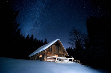 Yıldızların altında kış ormandaki güzel ahşap ev