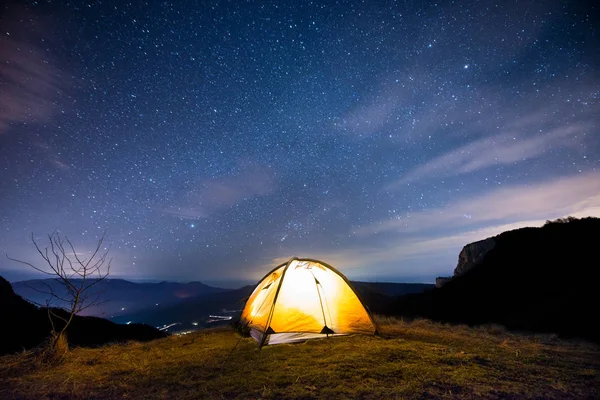 Светящийся шатер в горах под звездным небом — стоковое фото