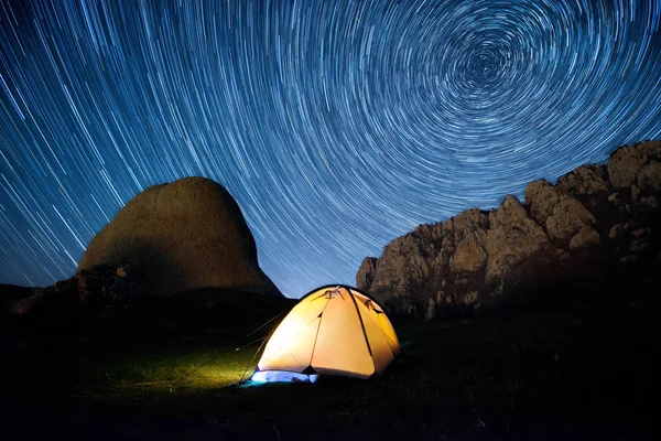 Звездные круги над горами и пылающий шатер — стоковое фото