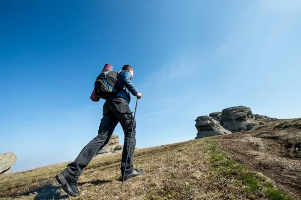Viajero con bastones de trekking y una mochila pasea por las montañas —  Fotos de Stock