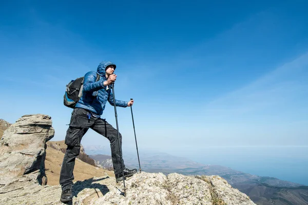 Viajero con bastones de trekking y una mochila en la parte superior de la m — Foto de Stock