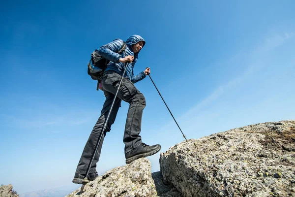 Reiziger met de trekking van de stokjes en een rugzak wandelingen in de mounta — Stockfoto