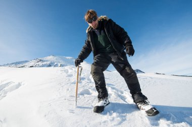 tırmanıcı bir buz balta ile karlı dağlarda yürür