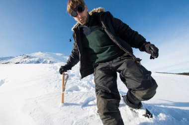 tırmanıcı bir buz balta ile karlı dağlarda yürür