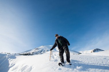 tırmanıcı bir buz balta ile karlı dağlarda yürür