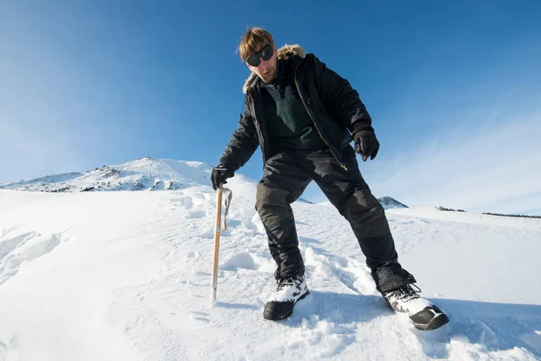 tırmanıcı bir buz balta ile karlı dağlarda yürür