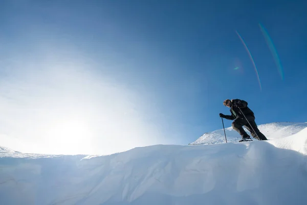 Wspinacz z kijki trekkingowe w snowy góry — Zdjęcie stockowe