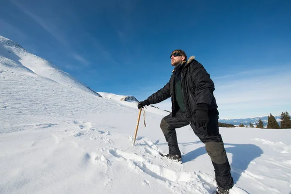 Альпинист с ледорубом в снежных горах — стоковое фото