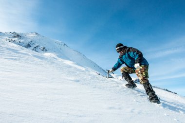 tırmanıcı bir buz balta ile karlı dağlarda yürür