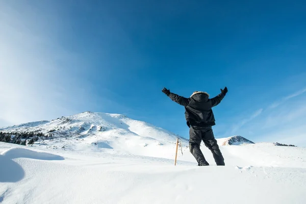 눈덮인 산에서 얼음 도끼를 든 행복 한 등산가 — 스톡 사진