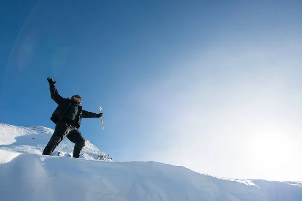 Szczęśliwy alpinista z toporem lodowym w śnieżnych górach — Zdjęcie stockowe