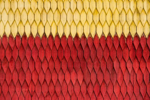 Parede de madeira desgastada velha com ornamento pintado em vermelho e amarelo. Textura vintage Fundo . — Fotografia de Stock