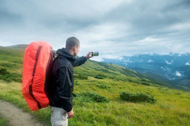 Seyahat etmek sırt çantası ve dağlarda smartphone ile