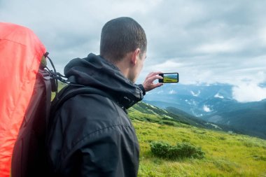 Seyahat etmek sırt çantası ve dağlarda smartphone ile