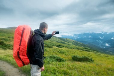 Seyahat etmek sırt çantası ve dağlarda smartphone ile