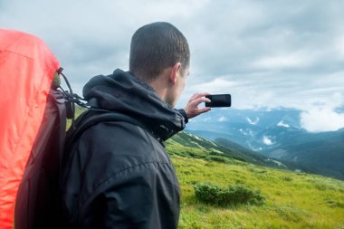 Seyahat etmek sırt çantası ve dağlarda smartphone ile