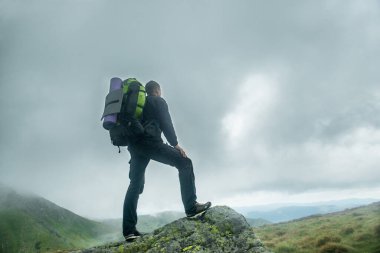 Gezgin bulutlar dağ üstünde sırt çantası ile