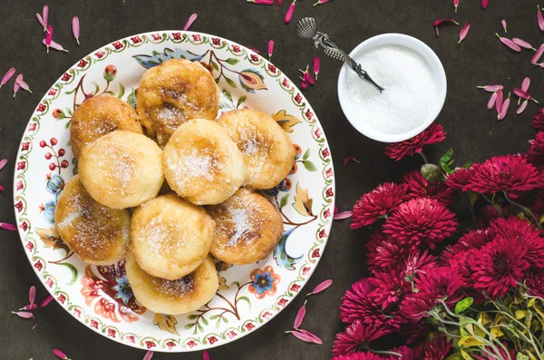 Groep van donuts met suiker op een plaat en chrysant — Stockfoto