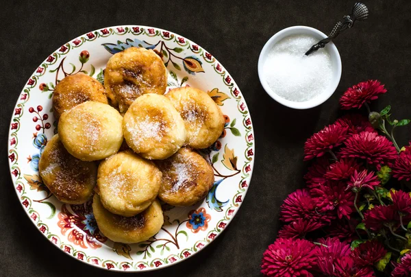 Gruppo di ciambelle con zucchero su un piatto e crisantemo — Foto Stock