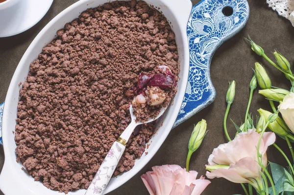 Schokoladenbrösel mit Birnen und Pflaumen und einem Blumenstrauß — Stockfoto