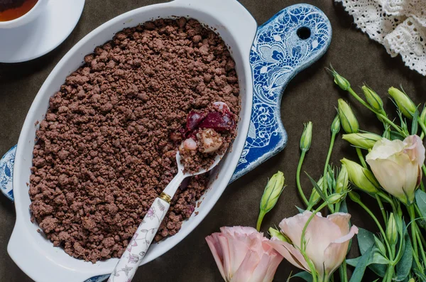Schokoladenbrösel mit Birnen und Pflaumen und einem Blumenstrauß — Stockfoto