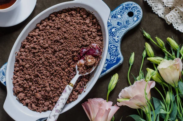 Schokoladenbrösel mit Birnen und Pflaumen und einem Blumenstrauß — Stockfoto