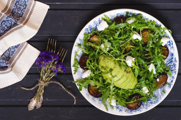 Arugula salad with goat cheese and avocado with plums — Stock Photo, Image