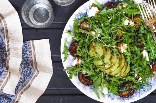 Arugula salad with goat cheese and avocado with plums