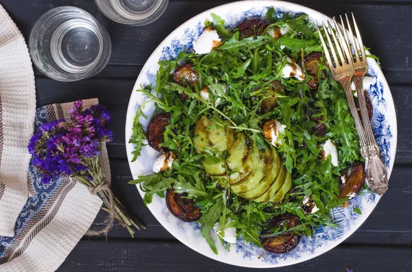 Салат из рукколы с козьим сыром и авокадо со сливами — стоковое фото