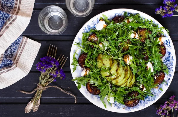 Arugula salad with goat cheese and avocado with plums
