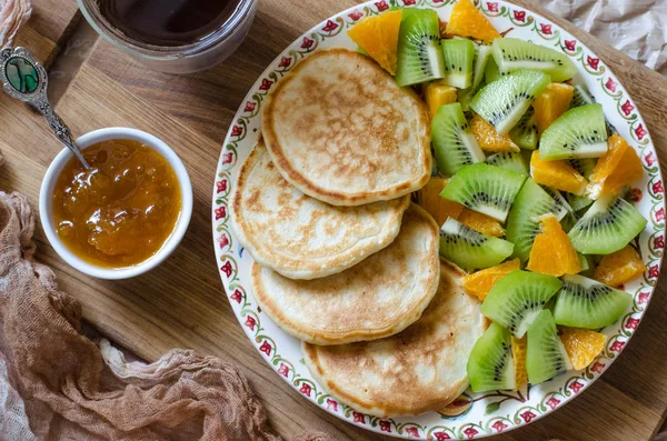 Pancakes with kiwi mandarins and jam for breakfast — Stock Photo, Image