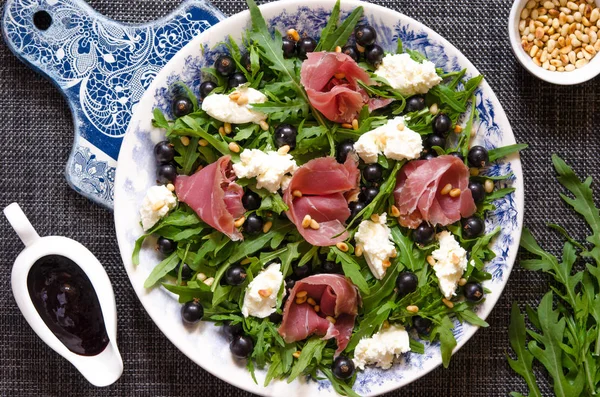 Sallad med parmaskinka ruccola mjuk ost cederträ nötter och svart c — Stockfoto