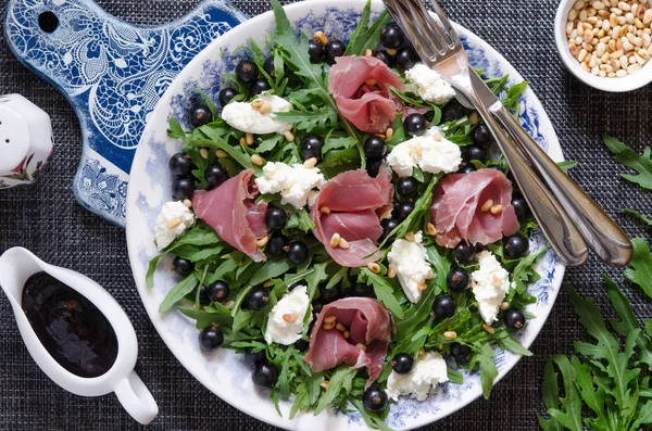 Sallad med parmaskinka ruccola mjuk ost cederträ nötter och svart c — Stockfoto