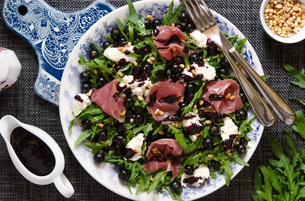 Sallad med parmaskinka ruccola mjuk ost cederträ nötter och svart c — Stockfoto