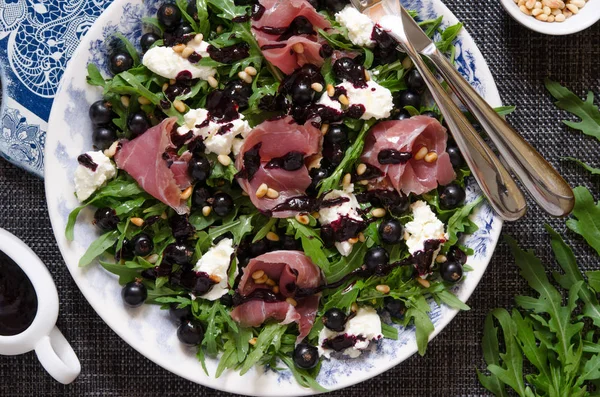 Sallad med parmaskinka ruccola mjuk ost cederträ nötter och svart c — Stockfoto