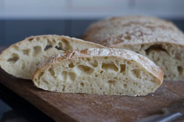 Tahtada dilimlenmiş İtalyan ciabatta ekmeği  