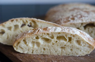 Tahtada dilimlenmiş İtalyan ciabatta ekmeği  