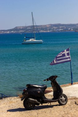 Yunanistan Rodos, 06 / 07 / 2018: Akdeniz Körfezi manzarası. Yunanistan bayrağı ve siyah bir scooter.