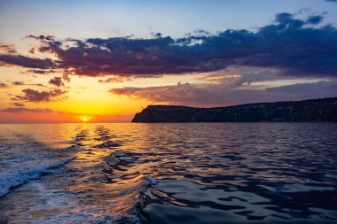 Okyanusta gün batımında öfkeli deniz dalgaları. Denizde fırtına bulutları.
