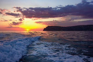 Okyanusta gün batımında öfkeli deniz dalgaları. Denizde fırtına bulutları.