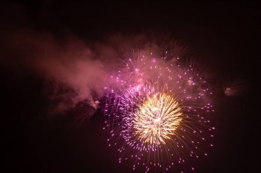 Geceleri gökyüzünde havai fişeklerin yakın plan fotoğrafı. Tatil için havai fişekler. Arkaplan.