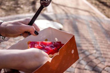 Kız sokakta kremalı pasta yiyor..