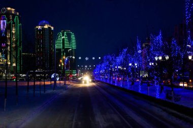 Rusya Çeçen Cumhuriyeti. Çok kötü. Şehir merkezinde fenerlerle kaplı karla kaplı bir sokak..