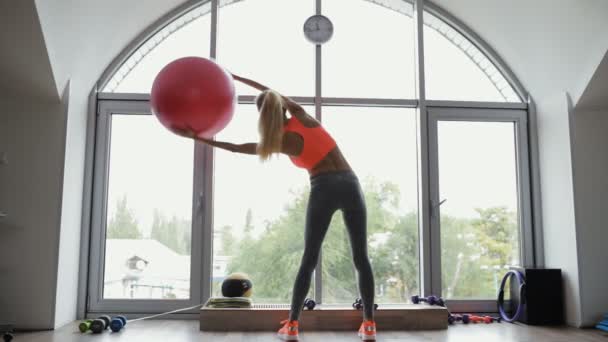 Kvinnan gör en sida som stretching motion hjälp fitball i fitnesstudio — Stockvideo