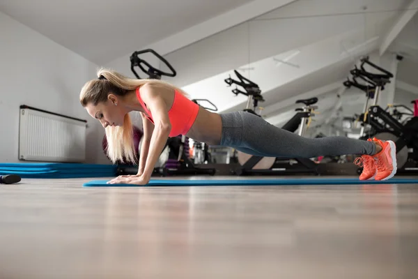 Mujer hacer flexiones en el gimnasio — Foto de Stock