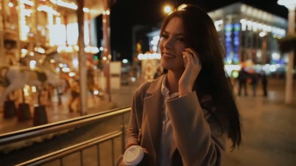 Moderne lachende vrouw spreken door smartphone in nacht stad — Stockvideo