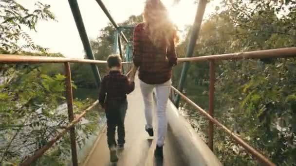 Moeder met zoon gaan op een bruggetje - terug weergave — Stockvideo