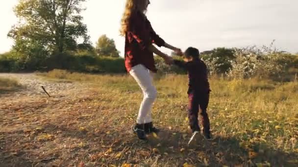 Anya örvény körül egy parkban, a fia, őszi nap — Stock videók