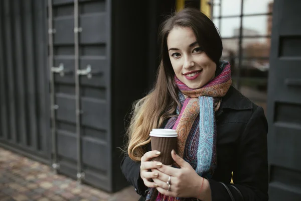 Vrouwelijke klant uit café met kop koffie voortvloeiende — Stockfoto